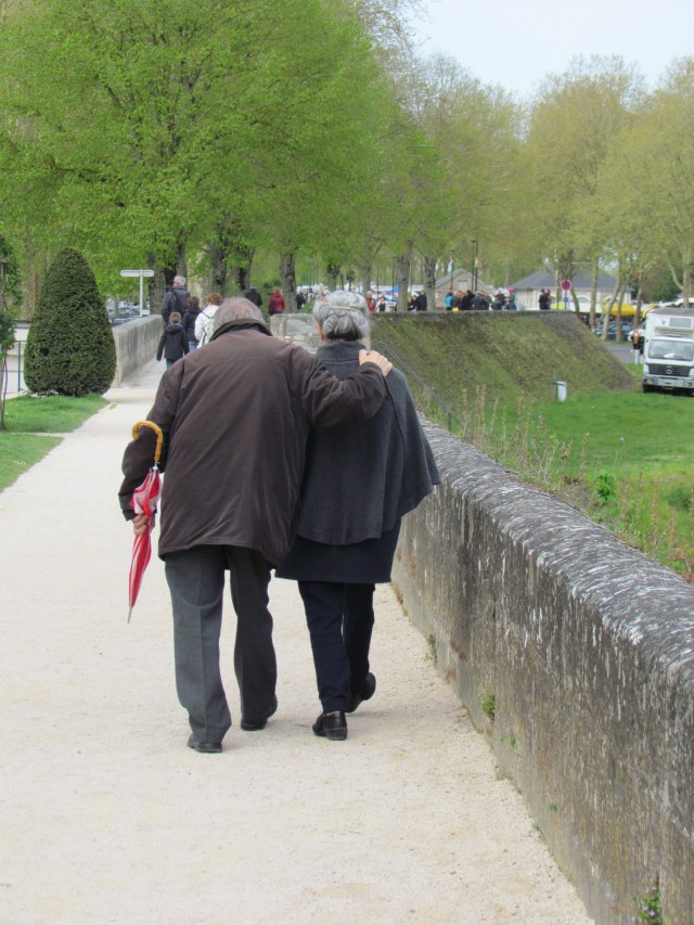 This cute old couple and their umbrella were headed to the market.