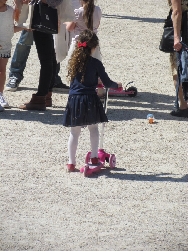This little girl riding her scooter in the park was so cute.